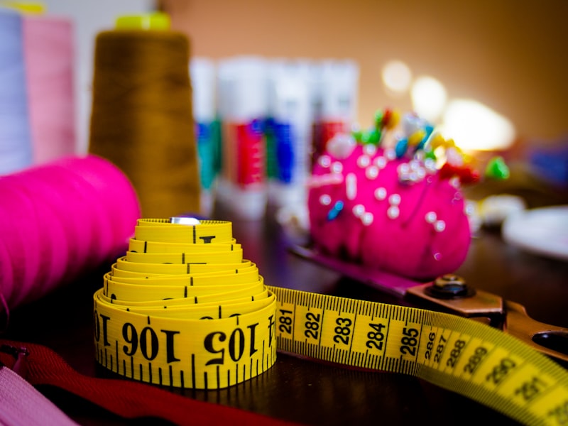 Measuring tape, thread spools, and sewing pins, dress alterations tools